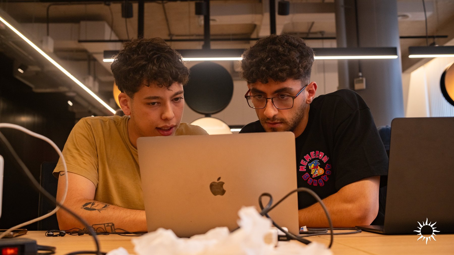 Two builders focused on their project during the Aleph Hackathon